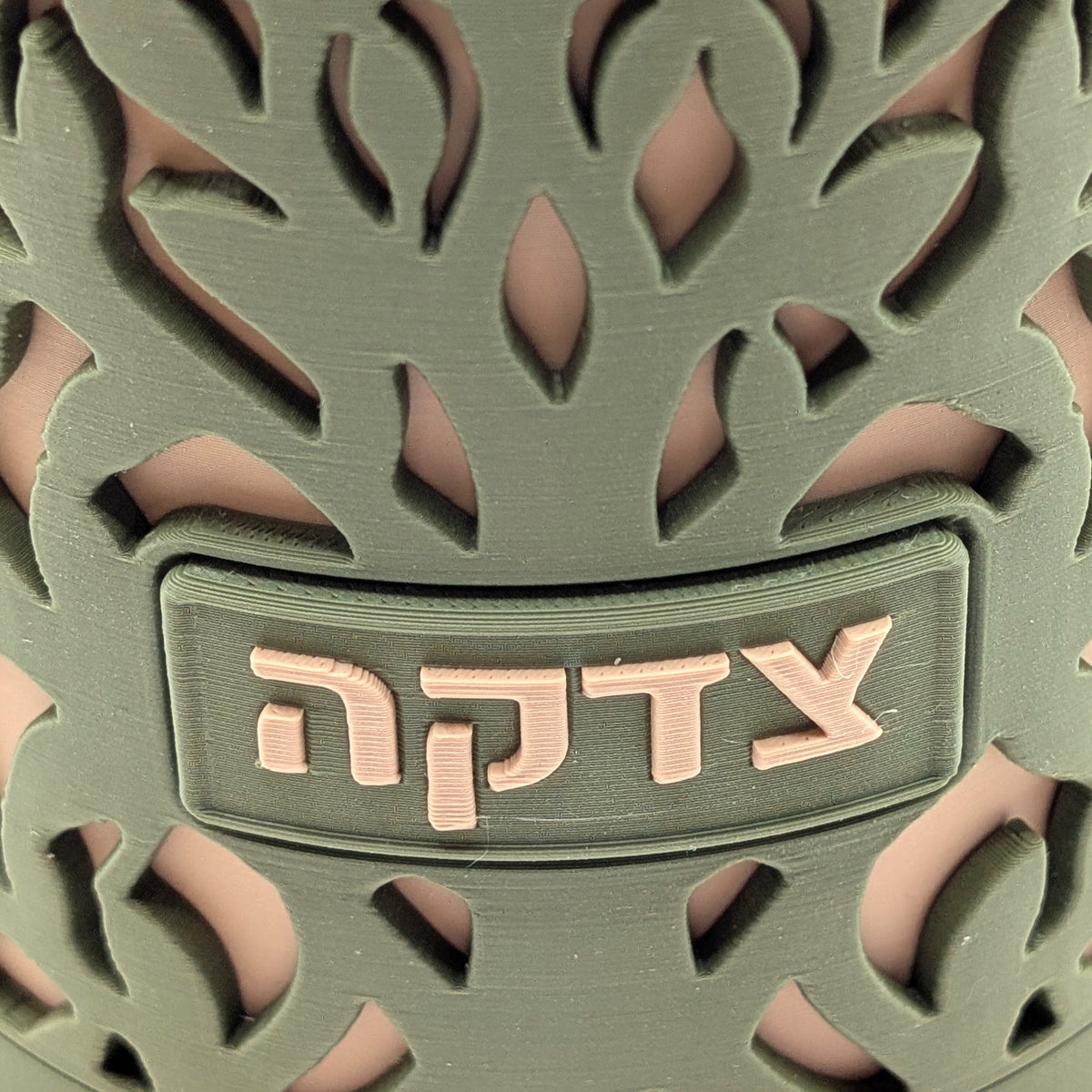 Close-up of the tzedakah plaque and branches on the Tree of Life tzedakah box